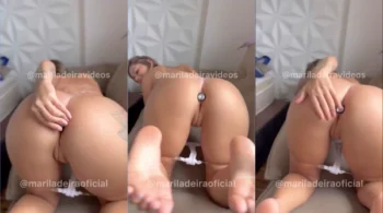 Loira ousada, sem roupas, preparando seu bundão apertadinho com lubrificante e inserindo um plug anal