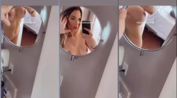 Leise Bach, só de pele, gravando um vídeo na frente do espelho